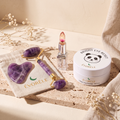 Évorèle Instant Edit Set — amethyst roller and gua sha, dried-flower jelly lip balm, collagen eye patches on travertine